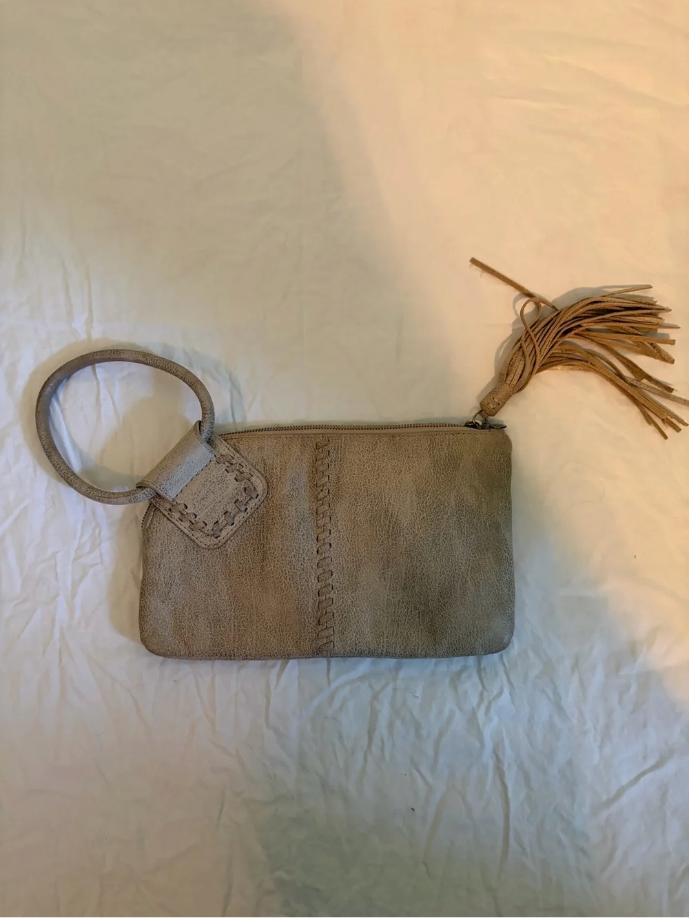 HOBO Sable wristlet in a tan/gold color with tassel